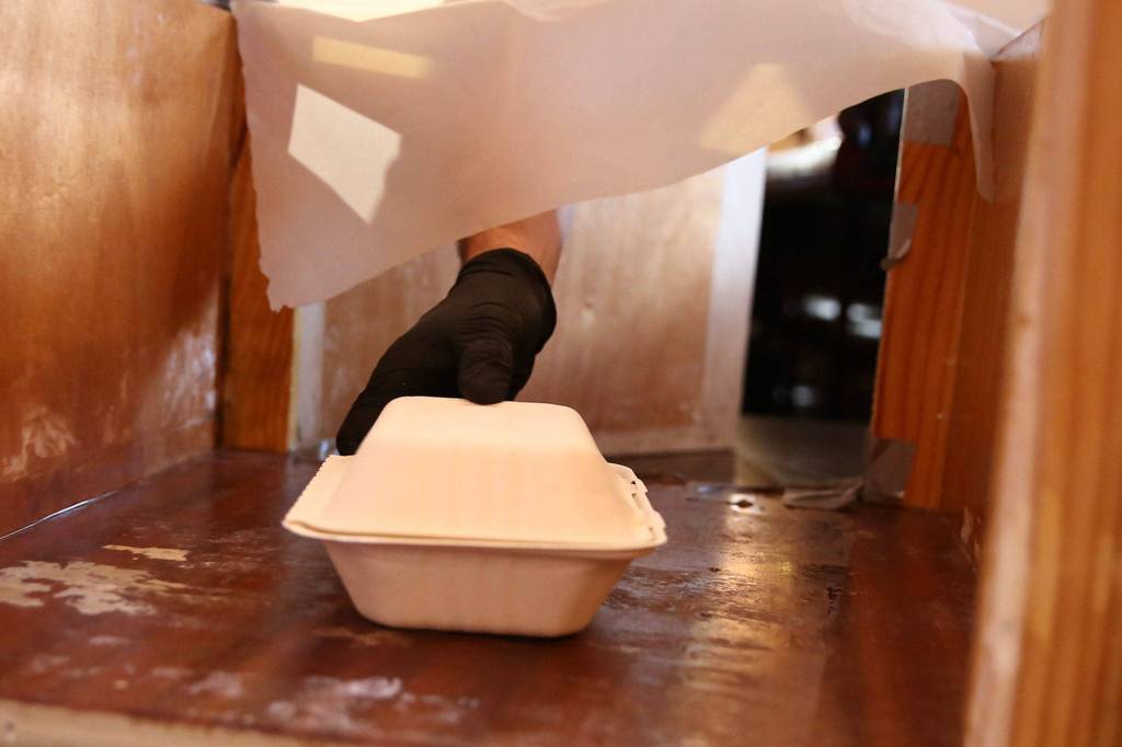Takeout food is placed in a box Thursday morning at Gabriels Fire in Mountlake Terrace on Sept. 24. (Kevin Clark / The Herald)