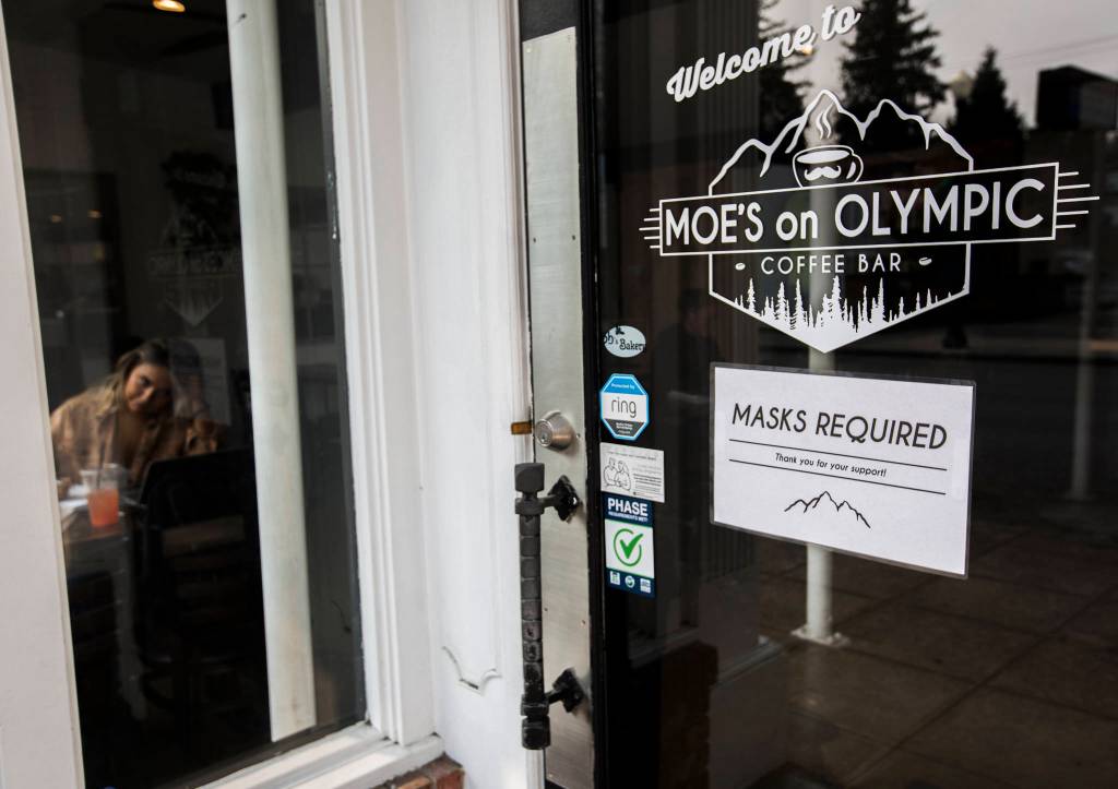 A sign at Moes on Olympic in Arlington reminds customers to wear a mask unless they are seated, eating or drinking. (Olivia Vanni / The Herald)