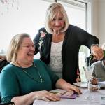 Founding member Janet Bacon pours champagne for Kit Massengale in a 2019 celebration of the formation of the new Snohomish County chapter of 100+ Women Who Care. Despite the pandemic, the group is ready to choose another organization to support. (Kevin Clark / The Herald)