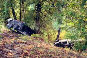 A pickup truck towing a cargo trailer flipped and rolled 30 feet down an embankment near Index on Thursday. (Washington State Patrol)