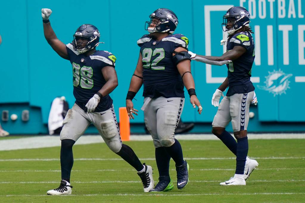 Seattle Seahawks defensive end Alton Robinson (98) celebrates after his tackle against Miami Dolphins running back Myles Gaskin (37) forced a field goal, during the second half of an NFL football game, Sunday, Oct. 4, 2020, in Miami Gardens, Fla. (AP Photo/Lynne Sladky)