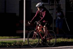 A biker looks right and slowly proceeds through a stop sign at 16th Street and Colby Avenue on Tuesday, Oct. 6, 2020 in Everett, Washington. As of Oct. 1, bike riders can treat stop signs like yield signs. (Andy Bronson / The Herald)
