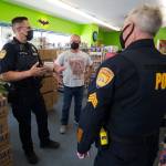 Everett Comics owner Charlie Knoedler and his wife Tracy talk with Everett Police Officers as they drop by to talk about the recent theft of a 4-foot tall Funko Batman Statue on Monday, Oct. 5, 2020 in Everett, Washington.  The statue was stolen in a “smash and grab” early Sunday. (Andy Bronson / The Herald)