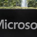 FILE - A man wearing a mask looks at this phone outside the Microsoft office in Beijing, China in a Friday, Aug. 7, 2020 file photo. Microsoft says the U.S. Labor Department is investigating its efforts to boost Black employment and leadership at the tech company. Microsoft disclosed in a blog post Tuesday, Oct. 6, 2020 that it received a letter from the agency last week asking about the company's June pledge to double the number of Black and African American people managers, senior individual contributors and senior leaders by 2025. (AP Photo/Ng Han Guan, File)