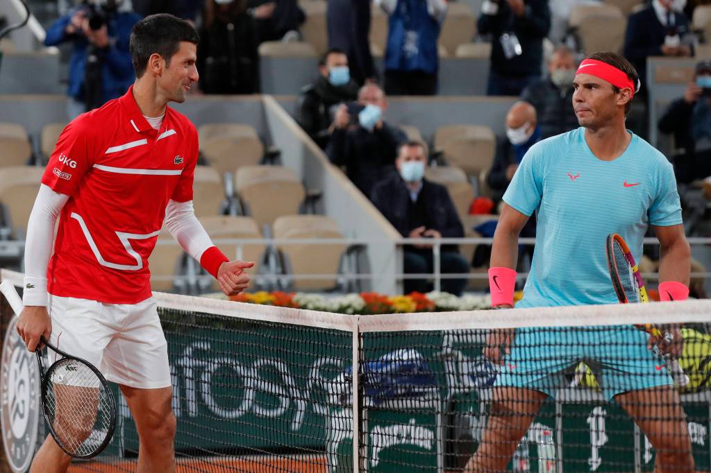 Serbia's Novak Djokovic, left, and Spain's Rafael Nadal look at each other as they pose for images prior to the final match of the French Open tennis tournament at the Roland Garros stadium in Paris, France, Sunday, Oct. 11, 2020. (AP Photo/Michel Euler)
