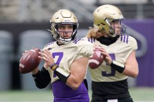 Washington quarterbacks Kevin Thomson, left, and Jacob Sirmon, right, drop to pass during NCAA college football practice, Friday, Oct. 16, 2020, in Seattle. (AP Photo/Ted S. Warren)