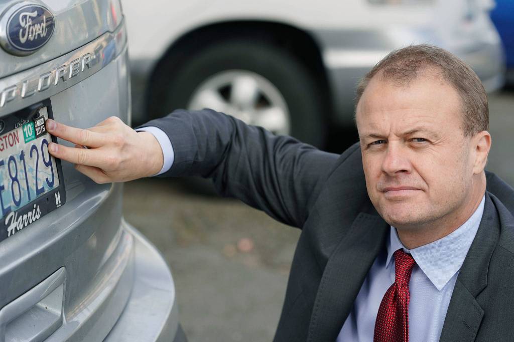 Initiative promoter Tim Eyman poses for a photo with his expired car registration tabs, Thursday, Oct. 15, 2020, at the Capitol in Olympia, Wash. The Washington Supreme Court on Thursday unanimously struck down Eyman's Initiative 976, a measure that would have steeply discounted the price of car registrations at $30 while gutting transportation budgets across Washington state. Eyman says he will continue to refuse to renew his tabs in protest over the initiative not being put into practice by the state. (AP Photo/Ted S. Warren)