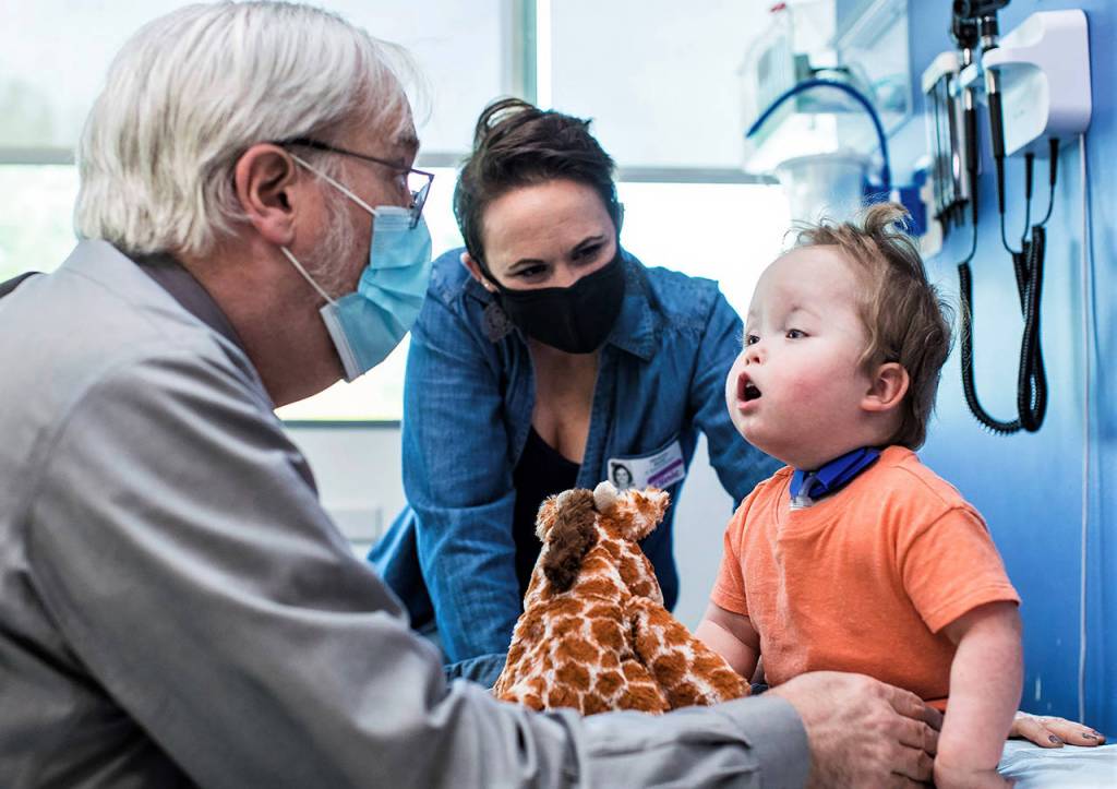 As his mother Whitney Stohr looks on, Malachi Stohr-Hendrickson, a 2-year-old born with spina bifida, is checked by Dr. William Walker. The doctor is a developmental pediatrics specialist with Seattle Childrens Hospital. (Seattle Childrens Hospital photo)