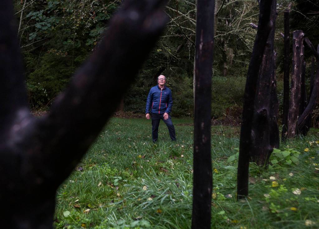 Environmental artist Chuck Pettis stands next to his Ley Line sculpture at Earth Sanctuary in Langley. Pettis founded the 72-arce park in 2000. (Olivia Vanni / The Herald)