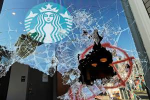 Broken windows are shown at a Starbucks store, Sunday, July 19, 2020 in Seattle's Capitol Hill neighborhood. Protesters broke windows at the store earlier in the afternoon. (AP Photo/Ted S. Warren)