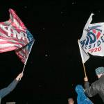 On West 12th Street across from the Erie International Airport, Steven Lantz-Gordon, 24, at left, of Harborcreek Township, waves a flag in support of President Donald Trump near David Oberg, 60, at right, of Grand Valley, who raises a flag in support of Democratic presidential candidate and former Vice President Joe Biden during a rally held by Trump, Tuesday, Oct. 20, 2020, at Erie International Airport, Tuesday, Oct. 20, 2020, in Millcreek Township, Pa. (Christopher Millette/Erie Times-News via AP)