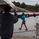 Everett Rowing Association rower Owen Moody, 17 (right) carries his single scull to the water. (Andy Bronson / The Herald)