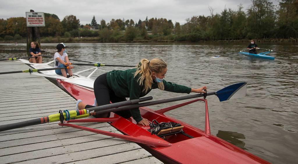 Everett Rowing Association rower Payton Wold flips an oarlock into place as she readies her single scull. (Andy Bronson / The Herald)