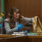 Jana Smith places her sister Jody Loomis' boot back into an evidence bag while testify on Wednesday, Oct. 28, 2020 in Everett, Wa. (Olivia Vanni / The Herald)