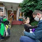 Alex Stonehill gets a goodbye from his daughter Helenore, 2, as her brother Malcolm, 4, motions to a friend arriving at the Community Day Center for Children on Thursday in Seattle. (AP Photo/Elaine Thompson)