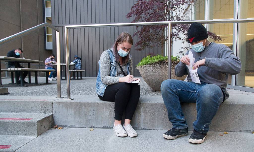 Voters Brie Roberts, 28, and Michael Woods, 30, vote for the first time at the Robert J. Drewel Administration Building on the Snohomsish County Campus on Monday in Everett.  (Andy Bronson / The Herald)