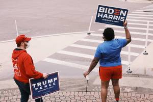 Robby Thurston, left, and Tamika Morris, right, volunteers for the rival Trump and Biden campaigns, wave signs in St. Petersburg, Fla.., a state where pollsters incorrectly predicted a close victory for Joe Biden. MUST CREDIT: photo for The Washington Post by Zack Wittman.