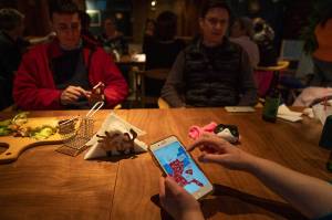 Expatriates monitor electoral maps on their mobile phones during an election watch event held by Democrats Abroad at a restaurant in Beijing, China on Nov. 4. (Ng Han Guan / Associated Press)