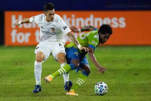 LA Galaxy forward Cristian Pavon, left, trips Seattle Sounders defender Joevin Jones during the first half of an MLS soccer match, Wednesday, Nov. 4, 2020, in Carson, Calif. (AP Photo/Ashley Landis)