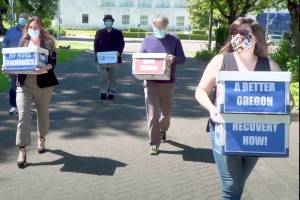 FILE - This June 26, 2020 file photo from video provided by the Yes on Measure 110 Campaign shows volunteers delivering boxes containing signed petitions in favor of the measure to the Oregon Secretary of State's office in Salem.  The measure said the U.S., possession of small amounts of heroin, cocaine, LSD and other hard drugs would be decriminalized in Oregon. Election returns show the measure passed on Election Day, Tuesday, Nov. 3. (Yes on Measure 110 Campaign via AP, File)
