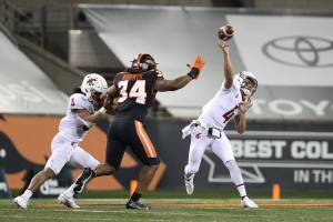 Washington State quarterback Jayden de Laura (4) throws past Oregon State inside linebacker Avery Roberts (34) and Washington State's Deon McIntosh (3) during the first half of an NCAA college football game in Corvallis, Ore., Saturday, Nov, 7, 2020. (AP Photo/Amanda Loman)