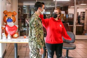 Anah Christenson (right) checks the temperature of an enlisted sailor Friday morning at Naval Station Everett. (Kevin Clark / The Herald)