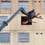A worker unloads two-by-fours from a forklift as construction continues on the new Compass Health project on 33rd Street on Nov. 18 in Everett. (Andy Bronson / The Herald)