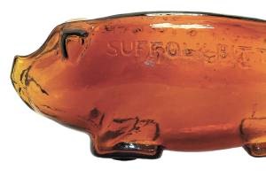 There have been copies of the antique Suffolk pig bottles in other colors of glass. The original bottle is 10 inches long and has a smooth base. (Cowles Syndicate Inc.)