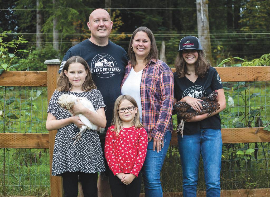 Jeremy and Heather Ballinger with their children Natalie, 11, left, Addy, 6, and Livia, 13, at their family farm. (Olivia Vanni / The Herald)