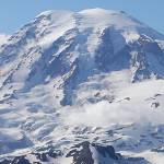 FILE - In this file photo taken June 19, 2013, Mount Rainier is seen from a helicopter flying south of the mountain and west of Yakima, Wash. A helicopter rescued four climbers from near the summit of Mount Rainier Thursday, June 6, 2019, after they had been stranded on the Cascade Mountain peak for several days. (AP Photo/Elaine Thompson, File)