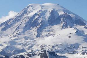 FILE - In this file photo taken June 19, 2013, Mount Rainier is seen from a helicopter flying south of the mountain and west of Yakima, Wash. A helicopter rescued four climbers from near the summit of Mount Rainier Thursday, June 6, 2019, after they had been stranded on the Cascade Mountain peak for several days. (AP Photo/Elaine Thompson, File)