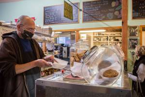 Burton Clemans, an employee at Sisters for 8 years, packages up a Sisters cookie on Tuesday, Nov. 17, 2020 in Everett, Wa. (Olivia Vanni / The Herald)