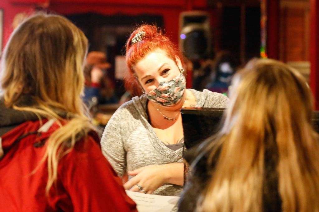 Michelle Peterson (center) helps customers at the AFK Tavern in Everett. (Kevin Clark / The Herald)