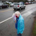 North County Family Services volunteer Mary Requa waits to hand out surveys for drivers waiting in line for a drive-through event for families in need called the Colors of Fall at the Darrington Food Bank on Monday. (Andy Bronson / The Herald)