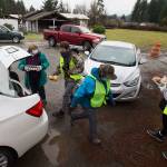Volunteers load a car with food during a drive-through event for families in need called the “Colors of Fall” at the Darrington Food Bank on Monday, Nov. 23, 2020 in Darrington, Washington. Stops along the drive-thru provided hand sanitizer, masks, food boxes, assistance information for those that need help with early learning, utilities, mental health, etc.  (Andy Bronson / The Herald)