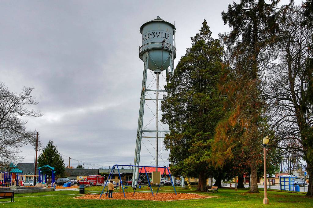 Marysville firefighters string lights on the Marysville water tower Friday. (Kevin Clark / The Herald)
