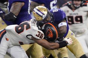 Washington running back Richard Newton is hit by linebacker Omar Speights during the first half of an NCAA college football game, Saturday, Nov. 14, 2020, in Seattle. (AP Photo/Ted S. Warren)