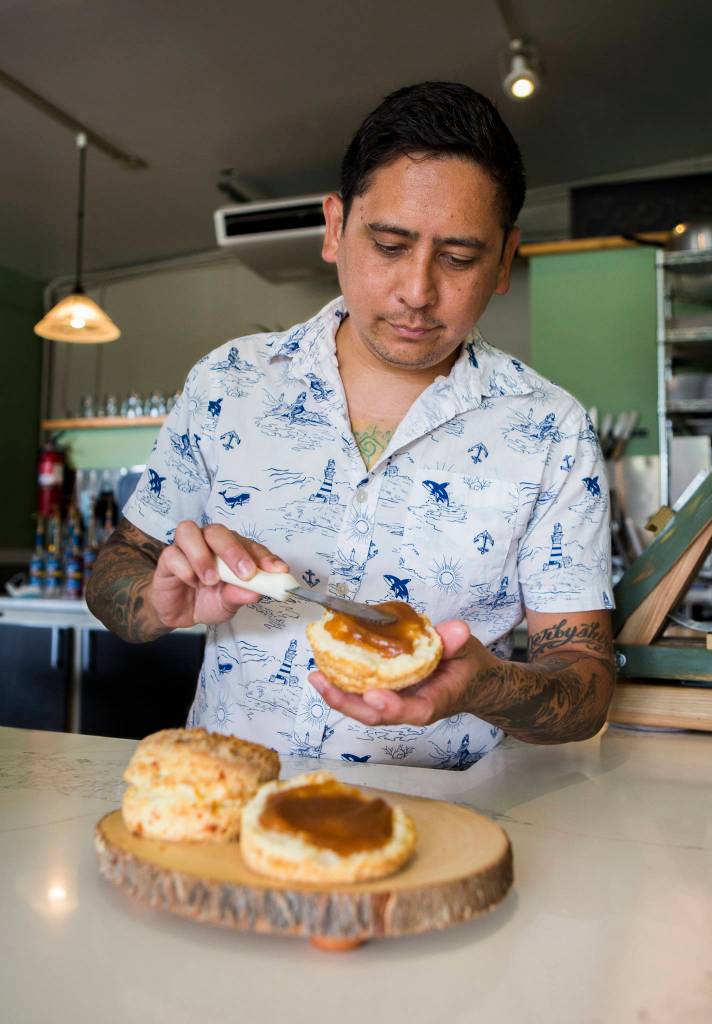 Biscuit Bean chef-owner Ben Libay spreads apple butter on a buttermilk biscuit at the Lake Stevens store. (Olivia Vanni / The Herald)