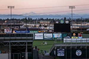 AquaSoxs Travis Kuhn and Emeralds Ryan Jensen an hour after the game between the two teams on Sunday continue standing in salute to the National Anthem at Funko Field on Sunday, Aug. 25, 2019 in Everett, Wash. (Olivia Vanni / The Herald)