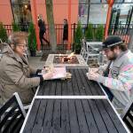 Diners Bonnie Breitman (left) and Casey McGan huddle near an outdoor gas fire as they eat lunch outside in a blustery wind Nov. 17 in Bellingham. (AP Photo/Elaine Thompson)