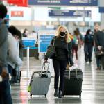A traveler wears a mask Sunday while walking through Terminal 3 at OHare International Airport in Chicago. Fridays total of new cases is the next-to-lowest daily number in the past 12 days, but Illinois state officials are bracing for another surge after many people around the country traveled for Thanksgiving and celebrated with family and friends. (AP Photo/Nam Y. Huh)