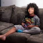 Dayvion Escalante, 9, plays Fortnite at home on Thursday, Nov. 19, 2020 in Everett, Washington. Dayvion was seven when he was severely burned on his leg and foot while drinking hot apple cider. He required a two month stay in the hospital.  (Andy Bronson / The Herald)