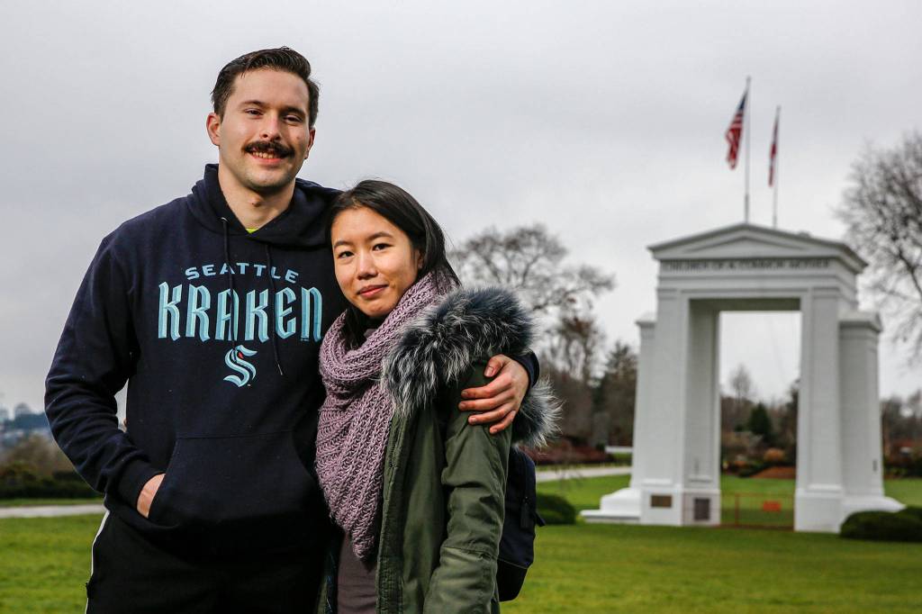 Bobby Warwick, a U.S. citizen, and Sarah Foo, a Canadian citizen, in front of the Peace Arch in Blaine. (Kevin Clark / The Herald)