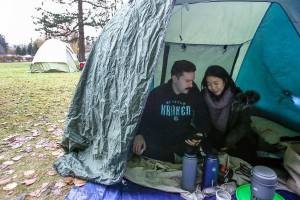 Bobby Warwick, a U.S. citizen, and his girlfriend Sarah Foo, of Canada, set up a makeshift tarp shelter at Peace Arch Park in Blaine, Wash. on November 22, 2020. (Kevin Clark / The Herald)