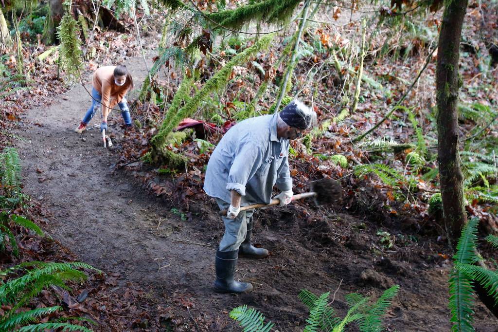 Jaime Larson (left) and Eric Christenson work construction of a new trail in Darrington on Nov. 27. (Kevin Clark / The Herald)