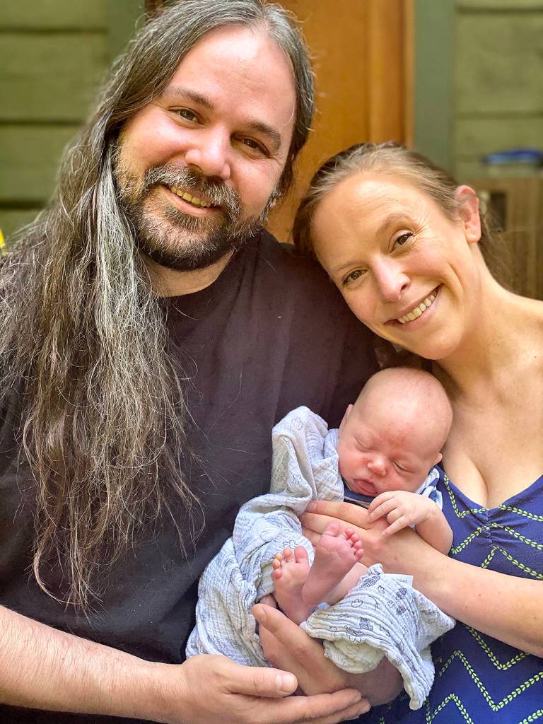 Charlotte Daphne-Celeste Buzard Simmons-Otness sleeps in the arms of her parents, Mark Buzard and Oriana Simmons-Otness. The baby was born Aug. 19 in Everett. Her first three initials are CDC. (Andrea Brown / The Herald)