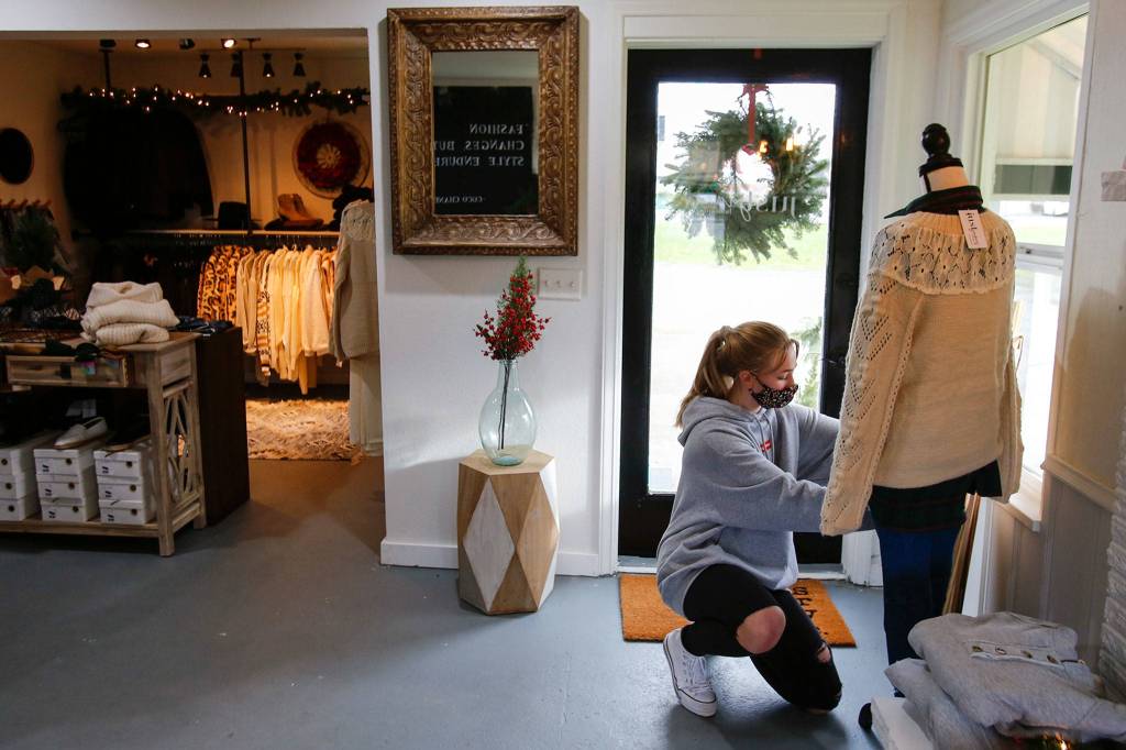 Claire Vondemkamp stages clothing at Just James Boutique in Stanwood. (Kevin Clark / The Herald)