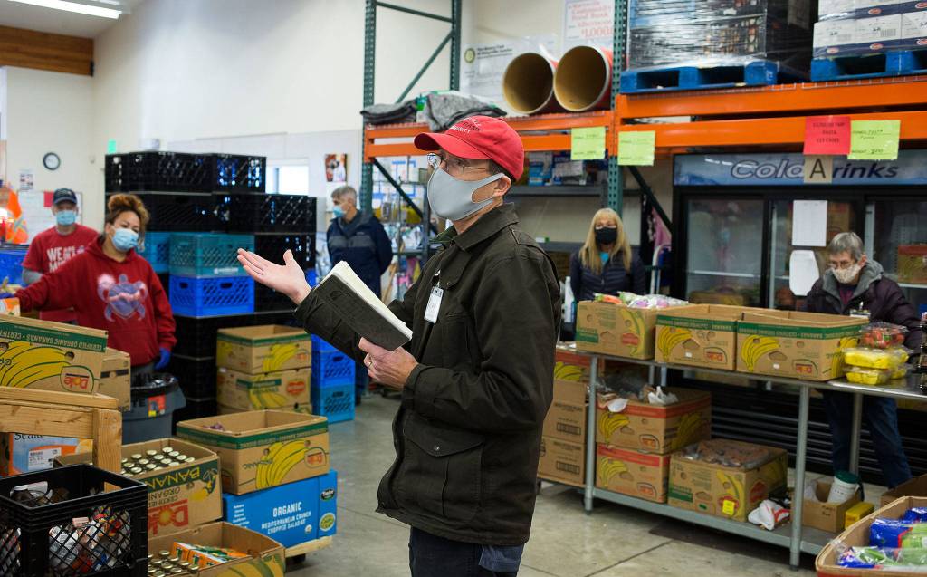 Dell Deierling, director of the Marysville Community Food Bank, talks with volunteers before they start handing out food Nov. 30. (Andy Bronson / The Herald)