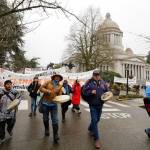 Climate activists and others supporting the Indigenous group Protectors of the Salish Sea march with signs and drums outside the Capitol at Olympia, Wash., Monday, Jan. 13, in Olympia, on the first day of the 2020 session of the Washington legislature. The group was at the Capitol to call attention to environmental issues including their demand that Gov. Jay Inslee declare a climate emergency and halt fossil fuel expansion projects in the state. (Ted S. Warren / Associated Press file photo)