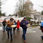 Climate activists and others supporting the Indigenous group "Protectors of the Salish Sea" march with signs and drums outside the Capitol at Olympia, Wash., Monday, Jan. 13, 2020, in Olympia, Wash., on the first day of the 2020 session of the Washington legislature. The group was at the Capitol to call attention to environmental issues including their demand that Gov. Jay Inslee declare a climate emergency and halt fossil fuel expansion projects in the state. (AP Photo/Ted S. Warren)